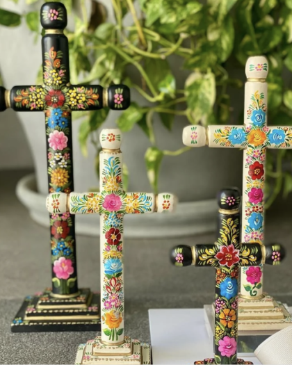 Cruz artesanal de madera con diseños florales